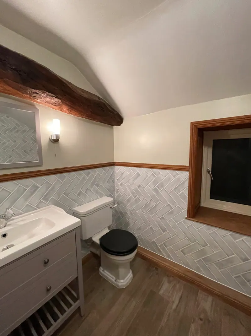 Cottage bathroom with herringbone tiling, vanity basin and close-coupled WC