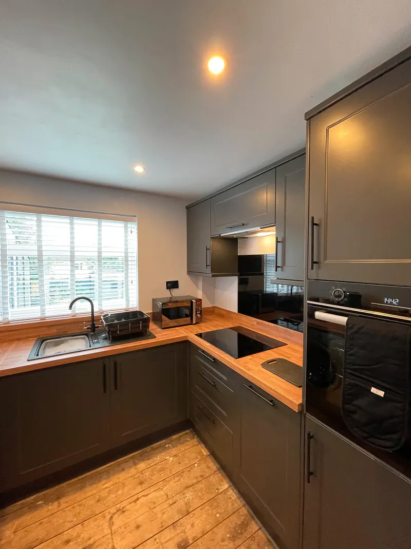 Charcoal shaker kitchen with wood worktops and black integrated appliances