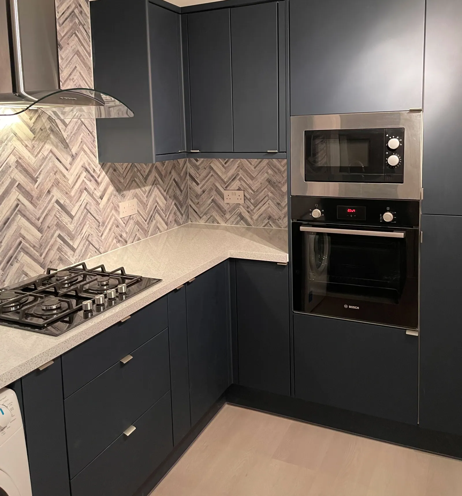 Navy shaker kitchen with herringbone marble splashback fitted by Gable & Bannister