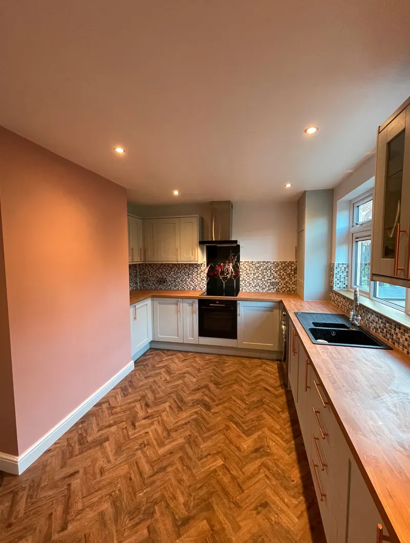 Galley kitchen with oak worktops and parquet-effect flooring