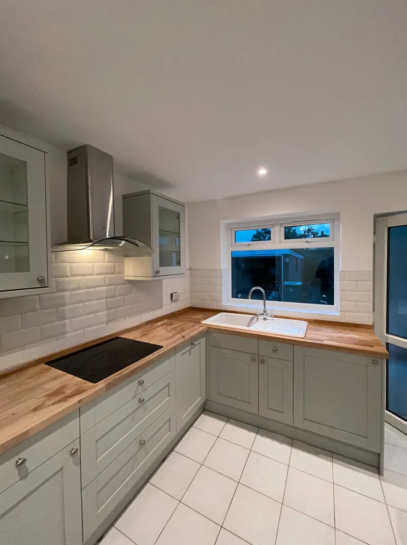 Sage shaker kitchen with solid oak worktops and metro tiles