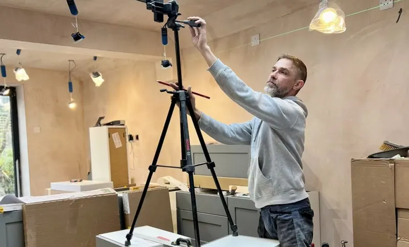 Steven setting out kitchen units with a laser level